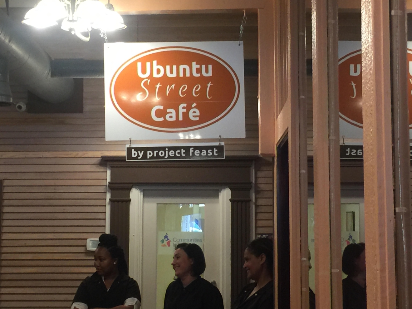 The three opening apprentices under the cafe sign (Image: Naomi Tomky)