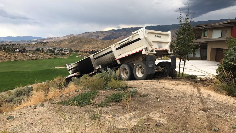Dump truck slides down embankment, nearly lands on golf course in west